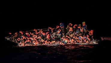 صورة ارشيفية- عشرات المهاجرين يقعون في المياه بينما يكافحون للتشبث بقارب مقلوب قبالة سواحل تونس (25 أيار 2022، أ ب). 