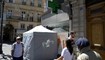 أشخاص يمرون قرب خيمة اختبار لكورونا على جانب الرصيف أمام صيدلية في باريس (29 حزيران 2022، أ ف ب). 