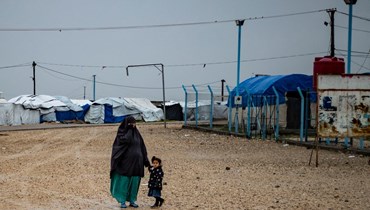 صورة ارشيفية- امرأة تمسك بيد طفلة في مخيم روج، حيث يُحتجز اقرباء أشخاص يشتبه في انتمائهم إلى داعش، في الريف قرب المالكية في محافظة الحسكة شمال شرق سوريا (4 آذار 2021، أ ف ب). 