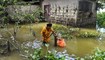 امرأة تعبئ ماء للشرب من بئر في قرية بارسيمولوا المتضررة من جراء فيضانات في منطقة نالباري بولاية آسام الهندية (24 حزيران 2022، أ ف ب). 