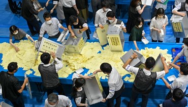 مسؤولون في لجنة إدارة الانتخابات يفرزون الأصوات في طوكيو في انتخابات مجلس الشيوخ (10 تموز 2022، أ ف ب). 