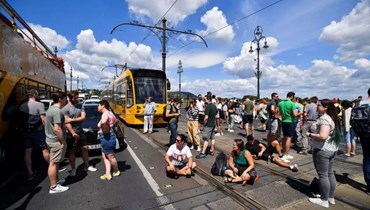 متظاهرون مجريون يغلقون جسراً في بودابست بسبب زيادة مزمعة للضرائب.