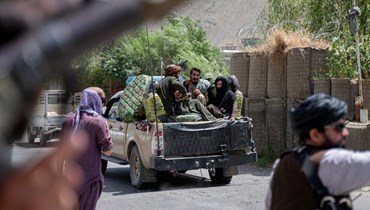 مقاتلون من طالبان يمرون عند نقطة تفتيش على الطريق قرب منطقة بازارك في مقاطعة بنجشير (8 تموز 2022، أ ف ب). 