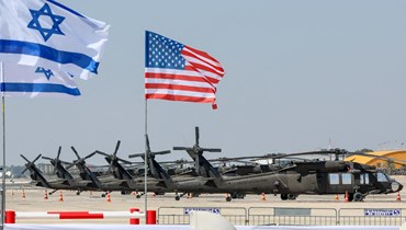 العلمان الأميركيّ والإسرائيليّ في مطار بن غوريون بتل أبيب قُبيل زيارة جو بادين (12 تموز 2022 - أ ف ب).