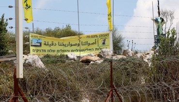 أعلام "حزب الله" عند الشريط الشائك الحدودي (أ ف ب).