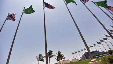 أعلام سعودية وأميركية مرحّبة بزيارة بايدن في جدّة (أ ف ب).