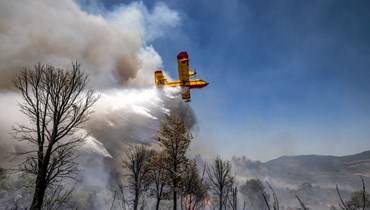 طائرة إطفاء خلال اخماد حريق غابة مستعر بالقرب من مدينة القصر الكبير المغربية في منطقة العرائش (14 تموز 2022، أ ف ب). 