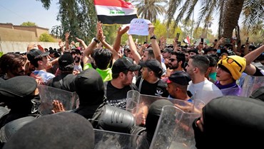 عراقيون يرددون هتافات تطالب بطرد السفير التركي، خارج مكتب التأشيرات التركية في بغداد (21 تموز 2022، أ ف ب). 