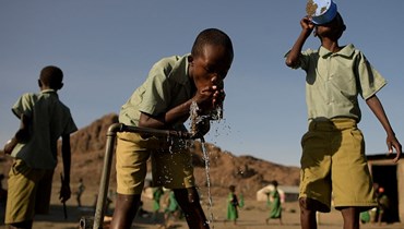 تلاميذ من مدرسة ال مولو باي الابتدائية يشربون من صنبور ماء  في لوايانغالاني شمال كينيا (13 تموز 2022، أ ف ب). 