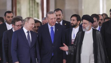 الرئيس التركي رجب طيب أردوغان يتوسط الرئيسين الروسي فلاديمير بوتين –إلى اليسار- والإيراني إبراهيم رئيسي (أ ف ب).