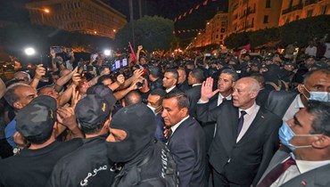 سعيّد (الى اليمين) محتفلا مع أنصاره في شارع الحبيب بورقيبة بالعاصمة تونس بعد إعلان النتيجة (26 تموز 2022، أ ف ب). 