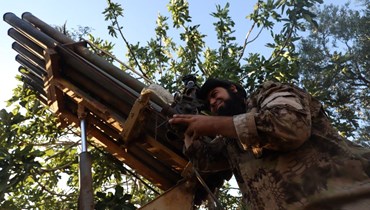 مقاتلون من المعارضة السورية في منطقة جبل الزاوية جنوب محافظة إدلب يستعدون لإطلاق صواريخ باتجاه مواقع النظام (22 تموز 2022، أ ف ب). 