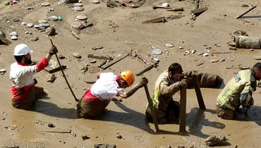 رجال إنقاذ انتشروا في موقع فيضان في الجزء الشمالي الغربي من إمام زاده داوود في طهران (28 تموز 2022، أ ف ب). 