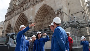عبد الملك (في الوسط) خلال تفقدها موقع إعادة بناء كاتدرائية نوتردام في باريس (28 تموز 2022، أ ف ب). 