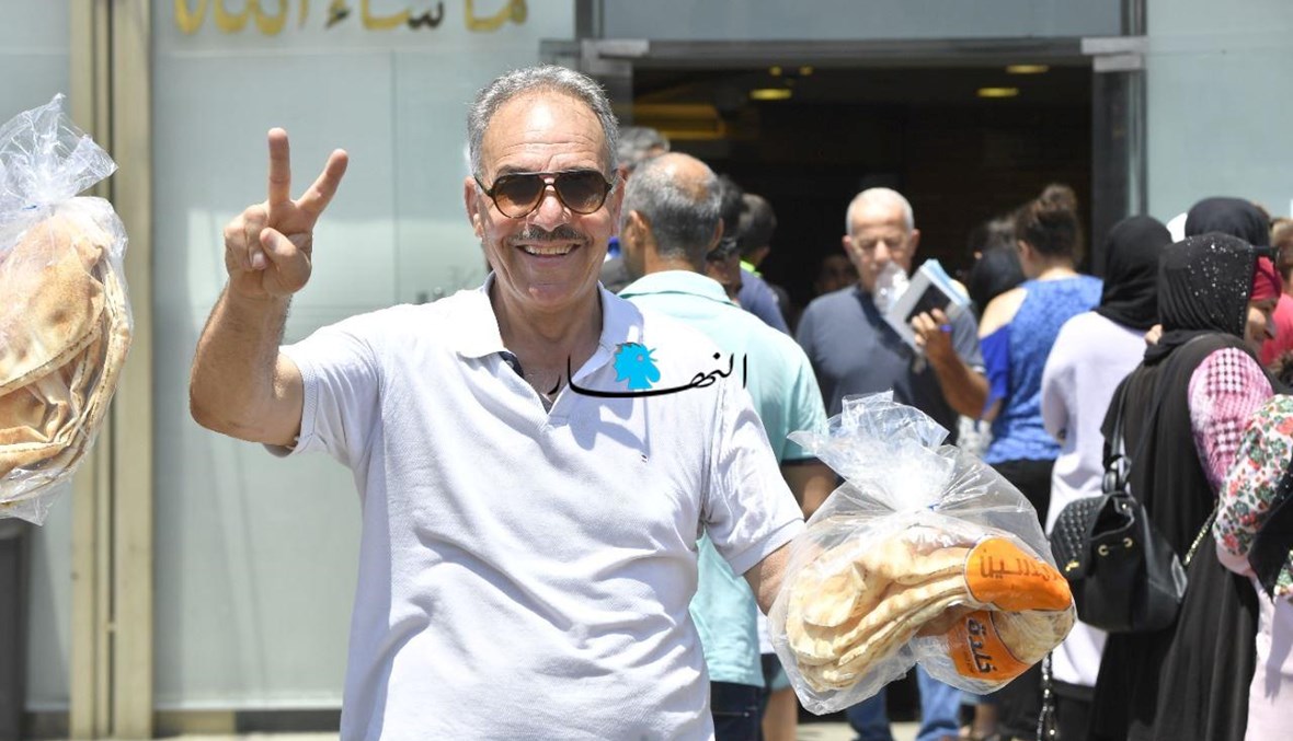 "فرحة" مواطن بالحصول على ربطة خبز أمام احد الأفران (حسام شبارو).