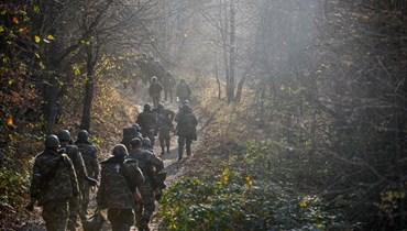 متطوعون عسكريون يسيرون على طريق وسط غابات في منطقة شوشا (31 ت1 2020، أ ف ب).