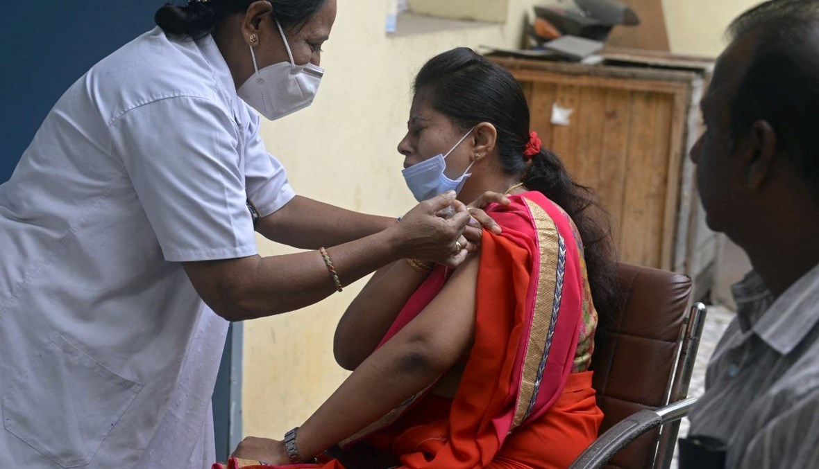 امرأة تتلقى جرعة من لقاح كورونا في حيدر أباد بالهند (2 آب 2022، أ ف ب). 