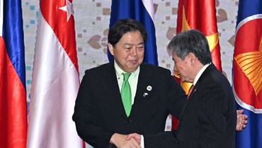 هاياشي (إلى اليسار) مصافحا الأمين العام لرابطة أمم جنوب شرق آسيا ليم جوك هوي خلال الاجتماع الوزاري بين آسيان واليابان في بنوم بنه (4 آب 2022، أ ف ب). 