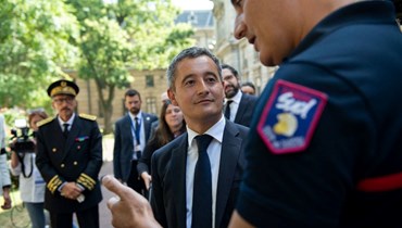 دارمانان (في الوسط) يتحدث الى رجل إطفاء خلال زيارته محافظة رون في ليون وسط شرق فرنسا (30 تموز 2022، أ ف ب). 