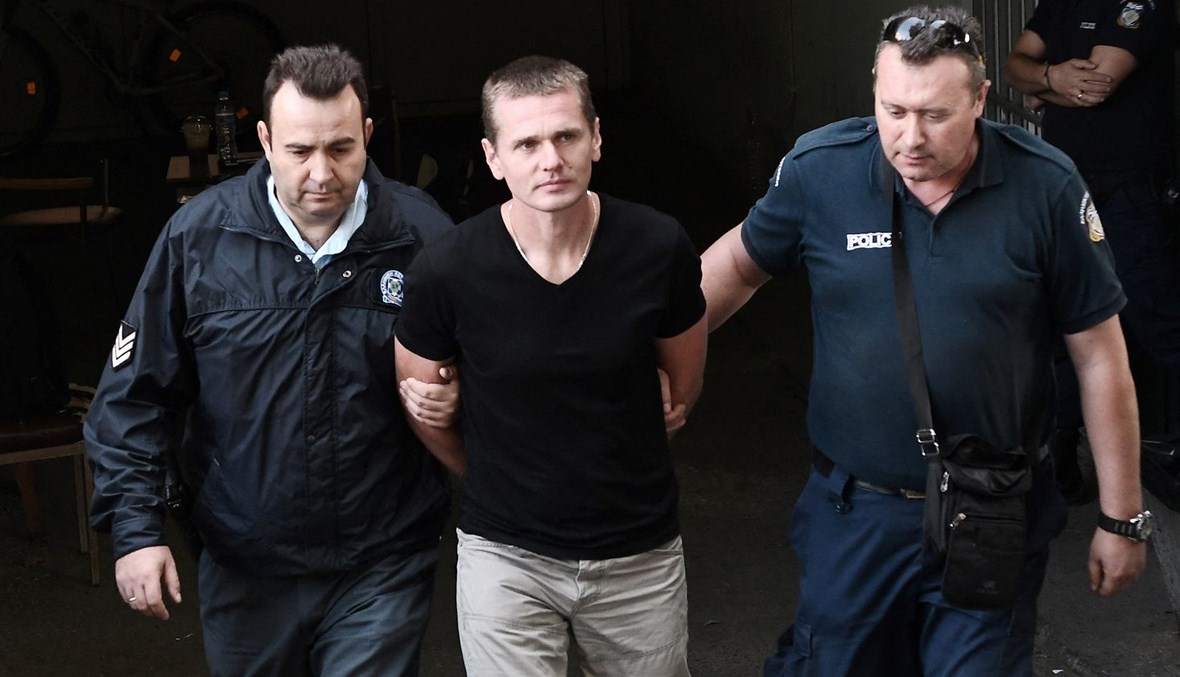 الروسي ألكسندر فينيك برفقة ضباط شرطة عند وصوله إلى محكمة في سالونيك (4 تشرين الأول 2017 - أ ف ب).