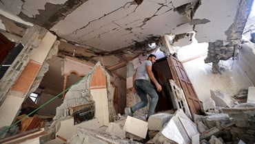 فلسطيني يمشي بين أنقاض منزله المتضرر من جراء الغارات الجوية الإسرائيلية على مدينة غزة (7 آب 2022، أ ف ب). 