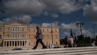 رجل يمر أمام مبنى البرلمان اليوناني في أثينا (8 آب 2022، أ ف ب). 