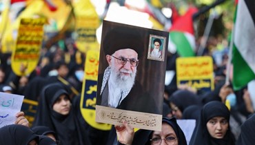 رفع صورة للمرشد الإيراني علي خامنئي في مسيرة دعماً لفلسطين في طهران (أ ف ب).