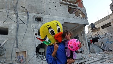 طفلة فلسطينية على أنقاض منزل مهدّم في غزّة (أ ف ب).