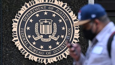 شخص يمر قرب شعار "وزارة العدل، مكتب التحقيقات الفيدرالي" على مبنى جيه إدغار هوفر في واشنطن (15 آب 2022، أ ف ب). 