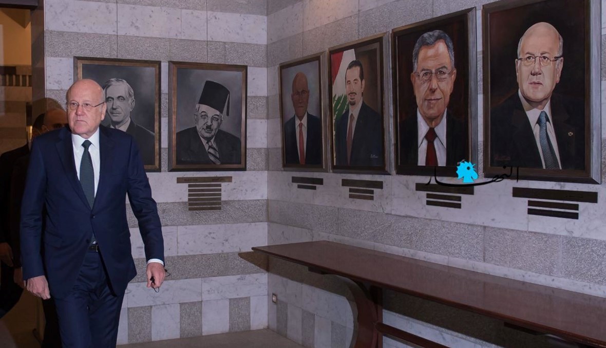 رئيس مجلس الوزراء نجيب ميقاتي في السرايا الحكومية إلى جانب صور الرؤساء السابقين للحكومات (نبيل إسماعيل).