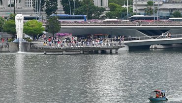 سياح تجمعوا عند تمثال الميرليون في الواجهة البحرية لخليج مارينا في سنغافورة (16 آب 2022، أ ف ب). 