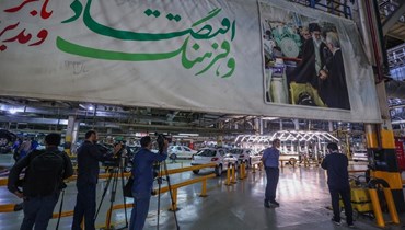 يلتقط صحفيون صوراً لخطوط إنتاج سيارات بيجو 207 و 206 في مصنع بإيران (أ ف ب).  