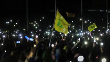  أنصار "حزب الله" يرفعون هواتفهم خلال احتفال في الضاحية الجنوبية لبيروت (أ ف ب).