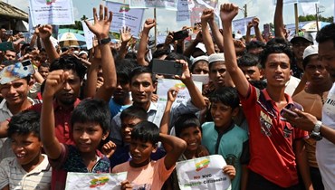 لاجئون من الروهينغا يرددون هتافات خلال مسيرة "يوم ذكرى الإبادة الجماعية" في مخيم للاجئين في أوخيا في بنغلادش (25 آب 2022، أ ف ب). 