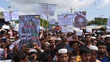 لاجئون من الروهينغا خلال مسيرة "يوم ذكرى الإبادة الجماعية" في مخيم للاجئين في أوخيا في بنغلادش (25 آب 2022، أ ف ب). 