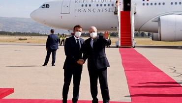 ماكرون (إلى اليسار) يستقبله تبون لدى وصوله إلى مطار الجزائر العاصمة (25 آب 2022، أ ف ب). 