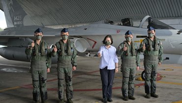 رئيسة تايوان تساي إنغ وين (في الوسط) تلتقط صورة مع طيارين من القوات الجوية أمام مقاتلة دفاعية في قاعدة جوية خلال تفقدها القوات العسكرية في جزر بينغو (30 آب 2022، أ ف ب). 