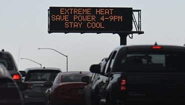 لافتة تحذّر من الحرارة الشديدة وتحضّ على الحفاظ على الطاقة أثناء موجة الحرّ، في وسط مدينة لوس أنجلوس، كاليفورنيا (2 أيلول 2022 - أ ف ب).