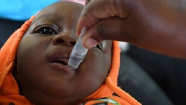 طفل في زيمبابوي يتلقّى جرعة من لقاح مرض الحصبة. 