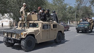  مقاتلو "طالبان" على متن سيارات أثناء احتفالهم بالذكرى السنوية الأولى لانسحاب القوات التي تقودها الولايات المتحدة من أفغانستان (أ ف ب). 