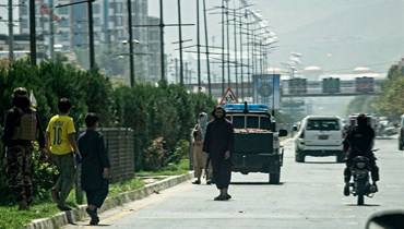 مقاتلون من طالبان (في الوسط) يقفون على طريق قرب السفارة الروسية بعد هجوم انتحاري في كابول (5 ايلول 2022، أ ف ب). 