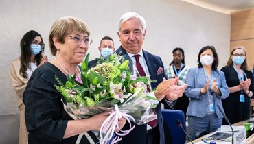 باشليه (إلى اليسار) تتلقى باقة من رئيس مجلس حقوق الإنسان التابع للأمم المتحدة فيديريكو فيلغاس (الثاني إلى اليسار) خلال وداعها في جنيف (30 آب 2022، أ ف ب).