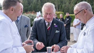 الأمير تشارلز يتذوق بعض الآيس كريم خلال زيارته موقع نيو لانارك في قائمة التراث العالمي لليونيسكو، في لاناركشاير باسكتلندا (7 أيلول 2022، ا ف ب). 