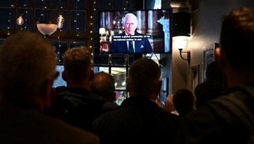 اشخاص في حانة وسط لندن يتابعون الخطاب المتلفز لملك بريطانيا تشارلز الثالث (9 أيلول 2022، أ ف ب). 