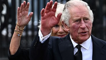 ملك بريطانيا تشارلز الثالث وزوجته كاميلا ملوحين للحشود لدى وصولهما الى قصر باكنغهام في لندن (9 أيلول 2022، أ ف ب). 