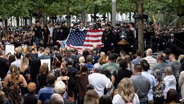 عناصر من إدارة الإطفاء في نيويورك يرفعون العلم الأميركي عند النصب التذكاري لاعتداءات 11 ايلول في نيويورك (11 أيلول 2022، أ ف ب). 