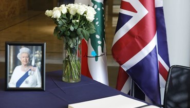 العلمان البريطاني واللبناني إلى جانب صورة للملكة إليزابيث في السفارة البريطانية في بيروت (مارك فياض).