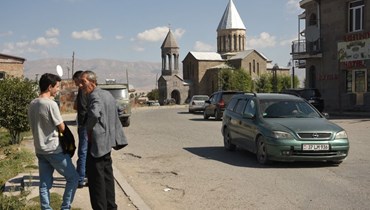 رجال يقفون على جانب طريق في مدينة فاردينيس بأرمينيا (15 أيلول 2022/ أ ف ب). 