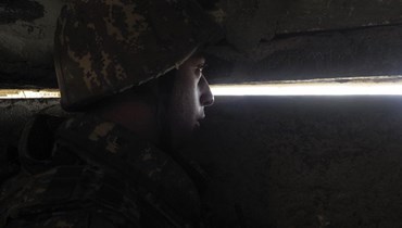 صورة ارشيفية- جندي أرميني يراقب من مخبأ في موقع قتالي على خط المواجهة خلال نزاع عسكري ضد القوات المسلحة الأذربيجانية في منطقة ناغورنو كراباخ (21 ت1 2020- أ ب).
