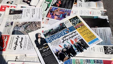 كشك يعرض الصحف في طهران، وعلى صفحات أولى صور لمهسا أميني ومقالات عنها (18 أيلول 2022، أ ف ب). 